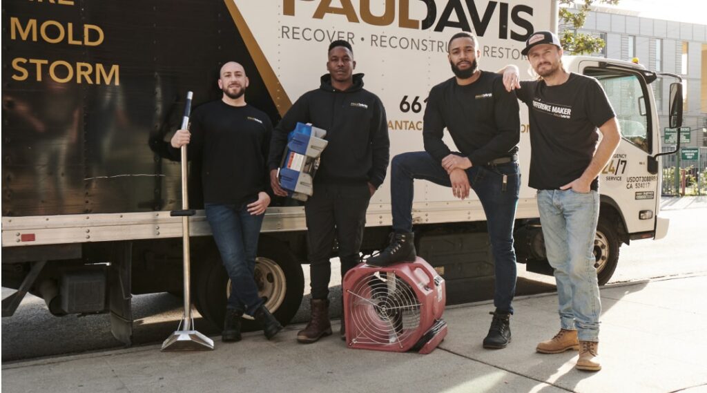Paul Davis Restoration team in Las Vegas standing beside service truck with water damage restoration equipment, ready for emergency cleanup and repair services